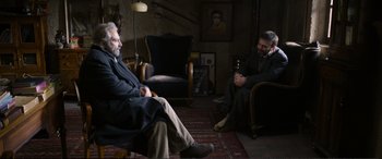 Movie still from “Winter Sleep” (2014), directed by Nuri Bilge Ceylan – Two men sitting in a living room talking to each other; Wide shot, Over the shoulder angle