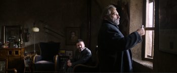 Movie still from “Winter Sleep” (2014), directed by Nuri Bilge Ceylan – Two men sitting in a chair in front of a painting; Medium shot, Over the shoulder angle