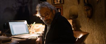 Movie still from “Winter Sleep” (2014), directed by Nuri Bilge Ceylan – An older man sitting at a table in front of a lamp; Medium shot, Low angle