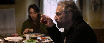Movie still from “Winter Sleep” (2014), directed by Nuri Bilge Ceylan – A man and a woman sitting at a dinner table; Medium shot, Over the shoulder angle