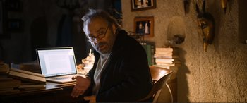 Movie still from “Winter Sleep” (2014), directed by Nuri Bilge Ceylan – An older man sitting in front of a laptop computer; Medium shot, Over the shoulder angle