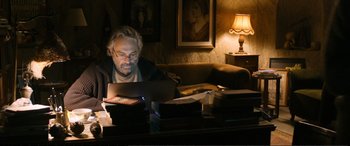 Movie still from “Winter Sleep” (2014), directed by Nuri Bilge Ceylan – A man sitting in front of a laptop computer on a table; Medium shot, High angle