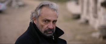 Movie still from “Winter Sleep” (2014), directed by Nuri Bilge Ceylan – An older man with a beard and a black jacket; Close Up shot, Over the shoulder angle