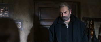 Movie still from “Winter Sleep” (2014), directed by Nuri Bilge Ceylan – A man in a black jacket is standing in a room; Medium shot, Over the shoulder angle