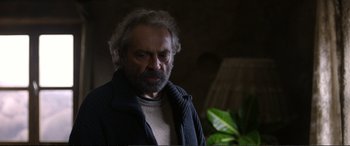 Movie still from “Winter Sleep” (2014), directed by Nuri Bilge Ceylan – An older man with a beard and a sweater; Close Up shot, Over the shoulder angle