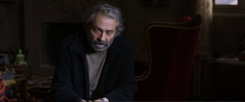 Movie still from “Winter Sleep” (2014), directed by Nuri Bilge Ceylan – An older man sitting in front of a chair; Medium shot, Over the shoulder angle