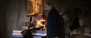 Movie still from “Winter Sleep” (2014), directed by Nuri Bilge Ceylan – A man standing in front of a laptop computer; Medium shot, Low angle