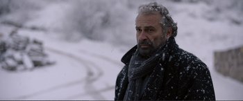 Movie still from “Winter Sleep” (2014), directed by Nuri Bilge Ceylan – A man in a black jacket and a gray scarf; Close Up shot, Low angle