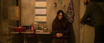 Movie still from “Winter Sleep” (2014), directed by Nuri Bilge Ceylan – A woman sitting in front of a table with a calendar on the wall; Medium shot, High angle