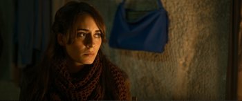 Movie still from “Winter Sleep” (2014), directed by Nuri Bilge Ceylan – A person wearing a scarf with a purse in the background; Close Up shot, Over the shoulder angle