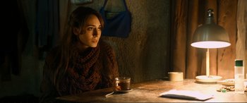 A woman sitting at a table with a cup of coffee