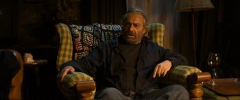 Movie still from “Winter Sleep” (2014), directed by Nuri Bilge Ceylan – An older man sitting on a chair in a living room; Medium shot, High angle