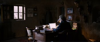 Movie still from “Winter Sleep” (2014), directed by Nuri Bilge Ceylan – A man sitting at a desk using a laptop computer; Wide shot, High angle