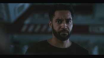 Movie still from “Another Life” (2019), created by Aaron Martin – A person with a beard looking straight ahead; Close Up shot, Over the shoulder angle