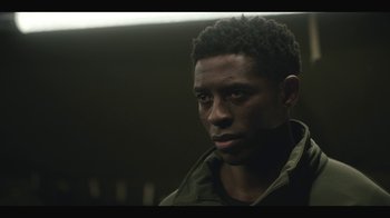 Movie still from “Another Life” (2019), created by Aaron Martin – A person wearing a green jacket; Close Up shot, Over the shoulder angle