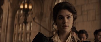 Movie still from “Winter's Tale” (2014), directed by Akiva Goldsman – A young woman in a black and white dress; Close Up shot, Over the shoulder angle