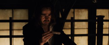 Movie still from “Winter's Tale” (2014), directed by Akiva Goldsman – A man in a dark room holding a knife; Close Up shot, Low angle