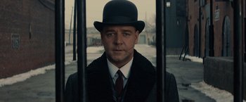 Movie still from “Winter's Tale” (2014), directed by Akiva Goldsman – A man wearing a black hat and a black coat; Close Up shot, Low angle