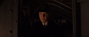 Movie still from “Winter's Tale” (2014), directed by Akiva Goldsman – A man wearing a hat and a suit and tie; Close Up shot, Low angle