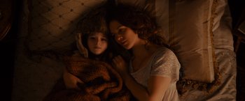 Movie still from “Winter's Tale” (2014), directed by Akiva Goldsman – A woman and a child laying in a bed together; Close Up shot, Overhead angle