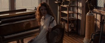 Movie still from “Winter's Tale” (2014), directed by Akiva Goldsman – A woman sitting on a chair in a room; Medium shot, High angle