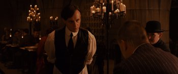 Movie still from “Winter's Tale” (2014), directed by Akiva Goldsman – A man wearing a white shirt and a black tie; Medium shot, Over the shoulder angle