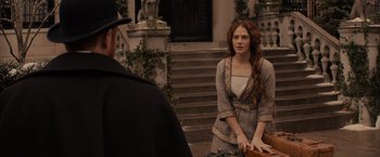 Movie still from “Winter's Tale” (2014), directed by Akiva Goldsman – A woman standing next to a man in front of a building; Medium shot, Over the shoulder angle