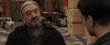 Movie still from “Winter's Tale” (2014), directed by Akiva Goldsman – An older man with a beard wearing a black jacket; Close Up shot, Over the shoulder angle