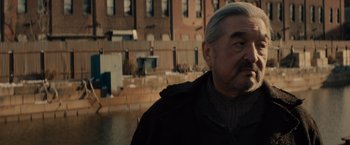 Movie still from “Winter's Tale” (2014), directed by Akiva Goldsman – An older man standing in front of a brick building; Close Up shot, Over the shoulder angle