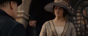 Movie still from “Winter's Tale” (2014), directed by Akiva Goldsman – A man and a woman standing next to each other in front of a building; Medium shot, Low angle