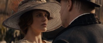 Movie still from “Winter's Tale” (2014), directed by Akiva Goldsman – A woman wearing a hat and a man wearing a suit; Close Up shot, Over the shoulder angle