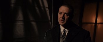 Movie still from “Winter's Tale” (2014), directed by Akiva Goldsman – A man wearing a suit and tie standing in front of a window; Close Up shot, Over the shoulder angle