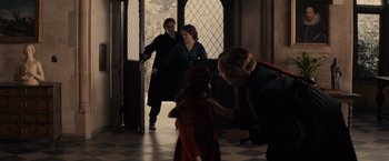 Movie still from “Winter's Tale” (2014), directed by Akiva Goldsman – Two people and a small child are in a room; Medium shot, Over the shoulder angle