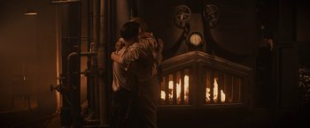 Movie still from “Winter's Tale” (2014), directed by Akiva Goldsman – Two people hugging in front of a fire place; Medium shot, Over the shoulder angle