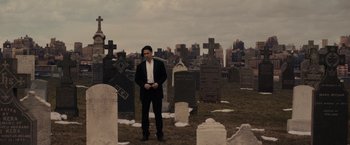A man standing in front of a graveyard
