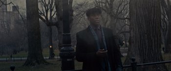 Movie still from “Winter's Tale” (2014), directed by Akiva Goldsman – A man in a suit and tie standing next to a lamp post; Medium shot, Low angle
