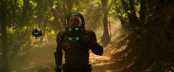 Movie still from “Wish I Was Here” (2014), directed by Zach Braff – A man in a space suit is standing in the woods; Medium shot, Over the shoulder angle