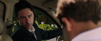 Movie still from “Wish I Was Here” (2014), directed by Zach Braff – A man in a suit and tie in the back of a car; Close Up shot, Over the shoulder angle
