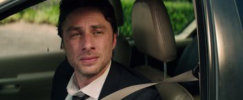 Movie still from “Wish I Was Here” (2014), directed by Zach Braff – A person sitting in a car wearing a seat belt; Close Up shot, Over the shoulder angle