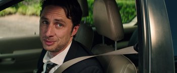 Movie still from “Wish I Was Here” (2014), directed by Zach Braff – A person sitting in a car wearing a suit; Close Up shot, Over the shoulder angle