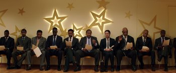 Movie still from “Wish I Was Here” (2014), directed by Zach Braff – A group of men in suits and ties sitting in a row; Wide shot, Low angle