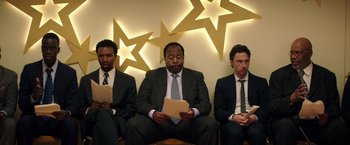 Movie still from “Wish I Was Here” (2014), directed by Zach Braff – A group of men sitting next to each other in suits; Medium shot, Low angle