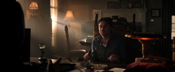 Movie still from “Wish I Was Here” (2014), directed by Zach Braff – A man sitting at a table in a room; Medium shot, Over the shoulder angle