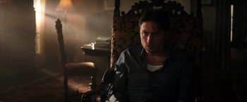 Movie still from “Wish I Was Here” (2014), directed by Zach Braff – A man sitting in a chair in a dark room; Medium shot, Low angle