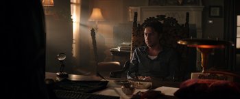 Movie still from “Wish I Was Here” (2014), directed by Zach Braff – A man sitting at a table in a dark room; Medium shot, Low angle