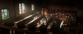 Movie still from “Wish I Was Here” (2014), directed by Zach Braff – A group of people sitting at desks in front of a stained glass window; Extreme Wide shot, High angle