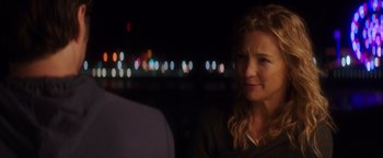 Movie still from “Wish I Was Here” (2014), directed by Zach Braff – A woman sitting in front of a man in front of lights; Close Up shot, Over the shoulder angle