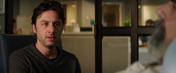 Movie still from “Wish I Was Here” (2014), directed by Zach Braff – A young man is standing in front of a window; Close Up shot, Over the shoulder angle