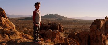 Movie still from “Wish I Was Here” (2014), directed by Zach Braff – A boy standing on top of a hill in the middle of the desert; Wide shot, Low angle