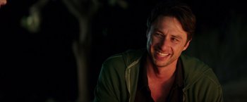 Movie still from “Wish I Was Here” (2014), directed by Zach Braff – A man smiling for the camera while wearing a green jacket; Close Up shot, Over the shoulder angle